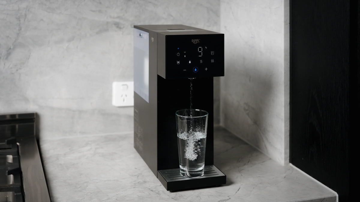 Rippl Nano in Black with a full glass of filtered water