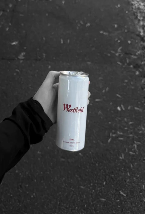 A Westfield can in hand on the street